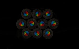 A group of multicolored discs sitting on top of a black surface